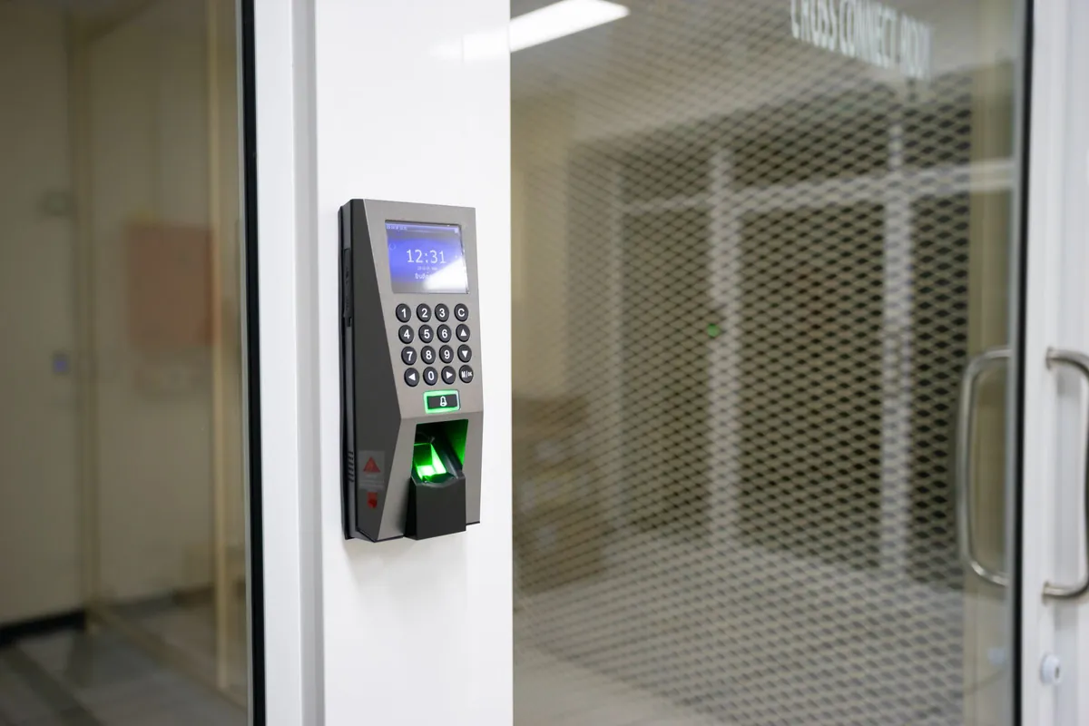 Keypad and PIN access control terminal beside a glazed office door